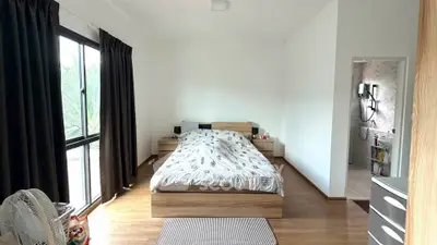 Spacious bedroom with modern decor and large window offering natural light.