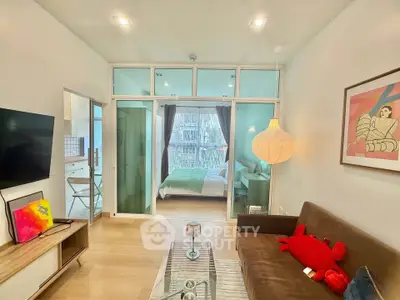 Modern living room with cozy decor and glass partition to bedroom