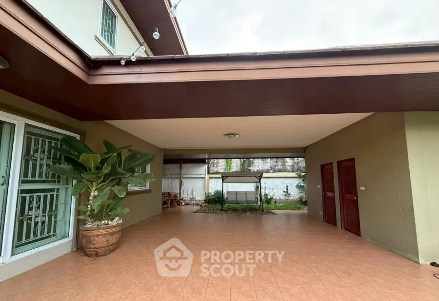 Spacious covered patio with tiled flooring and garden view in modern home