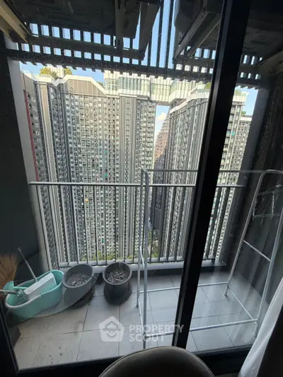 High-rise apartment balcony with cityscape view and potted plants.