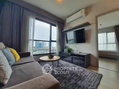 Modern living room with city view, cozy sofa, and wall-mounted TV in a stylish apartment.