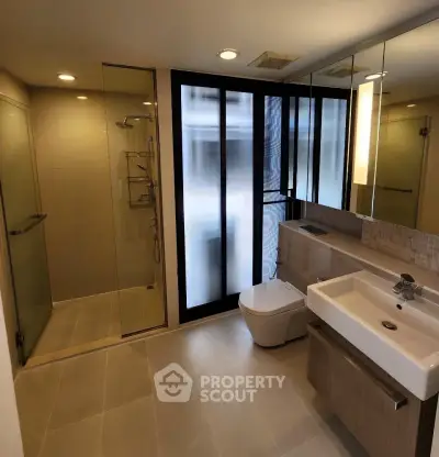 Modern bathroom with glass shower and sleek fixtures in a contemporary apartment.
