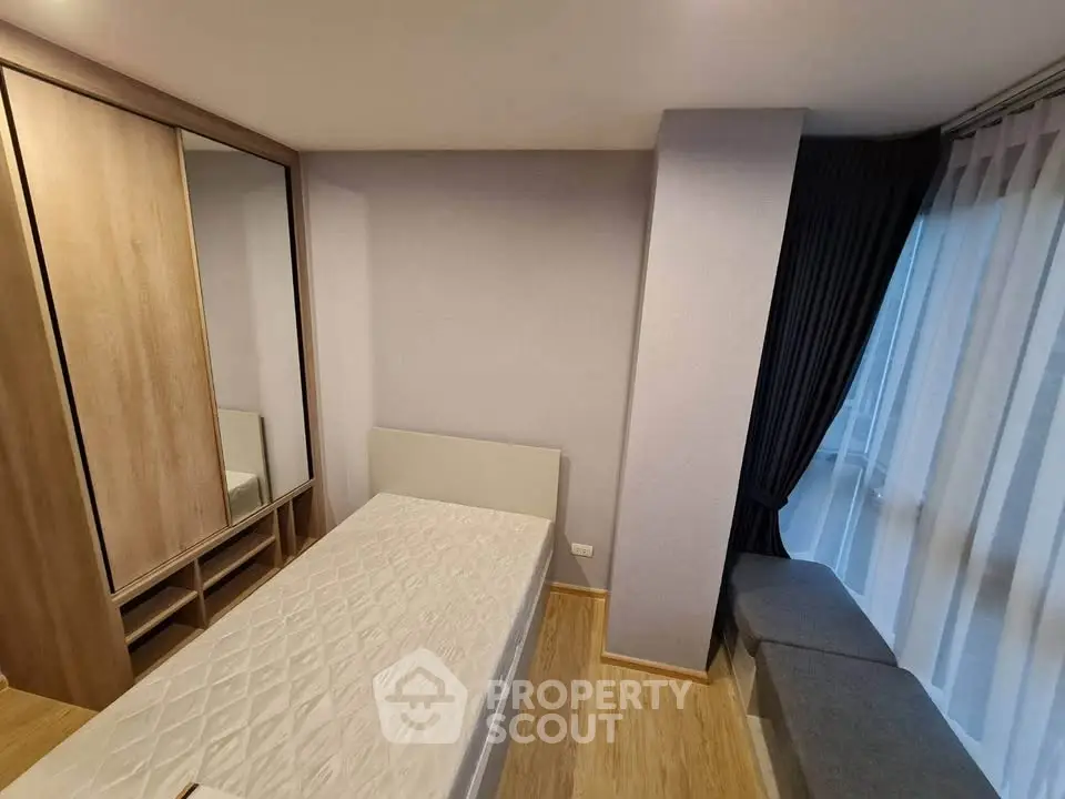 Cozy bedroom with modern design, featuring a single bed and built-in wardrobe, perfect for urban living.
