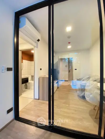 Modern apartment with glass partition and air conditioning, showcasing a sleek interior design.