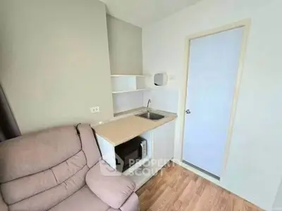 Compact kitchenette with sink and microwave in cozy living area