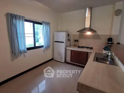 Spacious kitchen with gas stove and ample natural light, perfect for culinary enthusiasts.