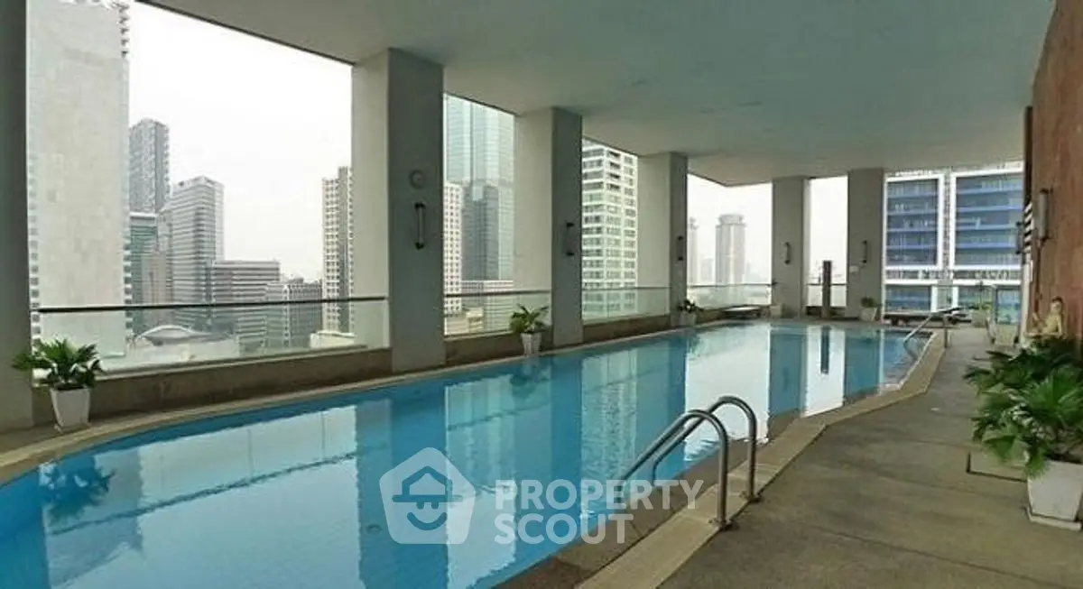 Luxurious rooftop pool with stunning city skyline views in modern high-rise building.