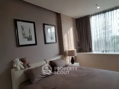 Cozy bedroom with modern decor and large window for natural light.