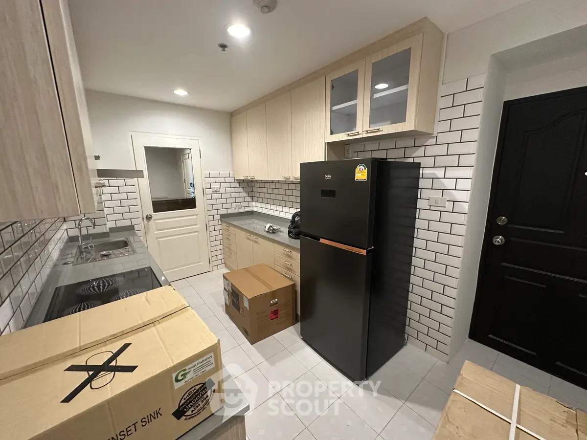 Modern kitchen with sleek appliances and stylish cabinetry in a contemporary apartment.