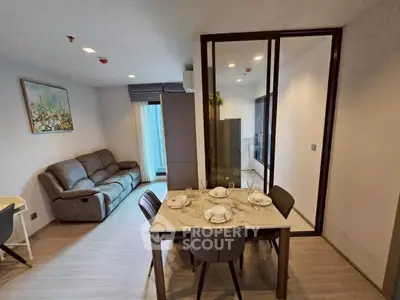 Modern living and dining area with sleek furniture and natural light.