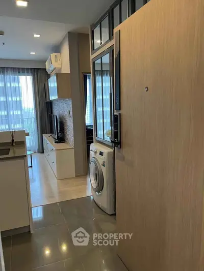 Modern apartment interior with open layout, featuring a washing machine and stylish decor.
