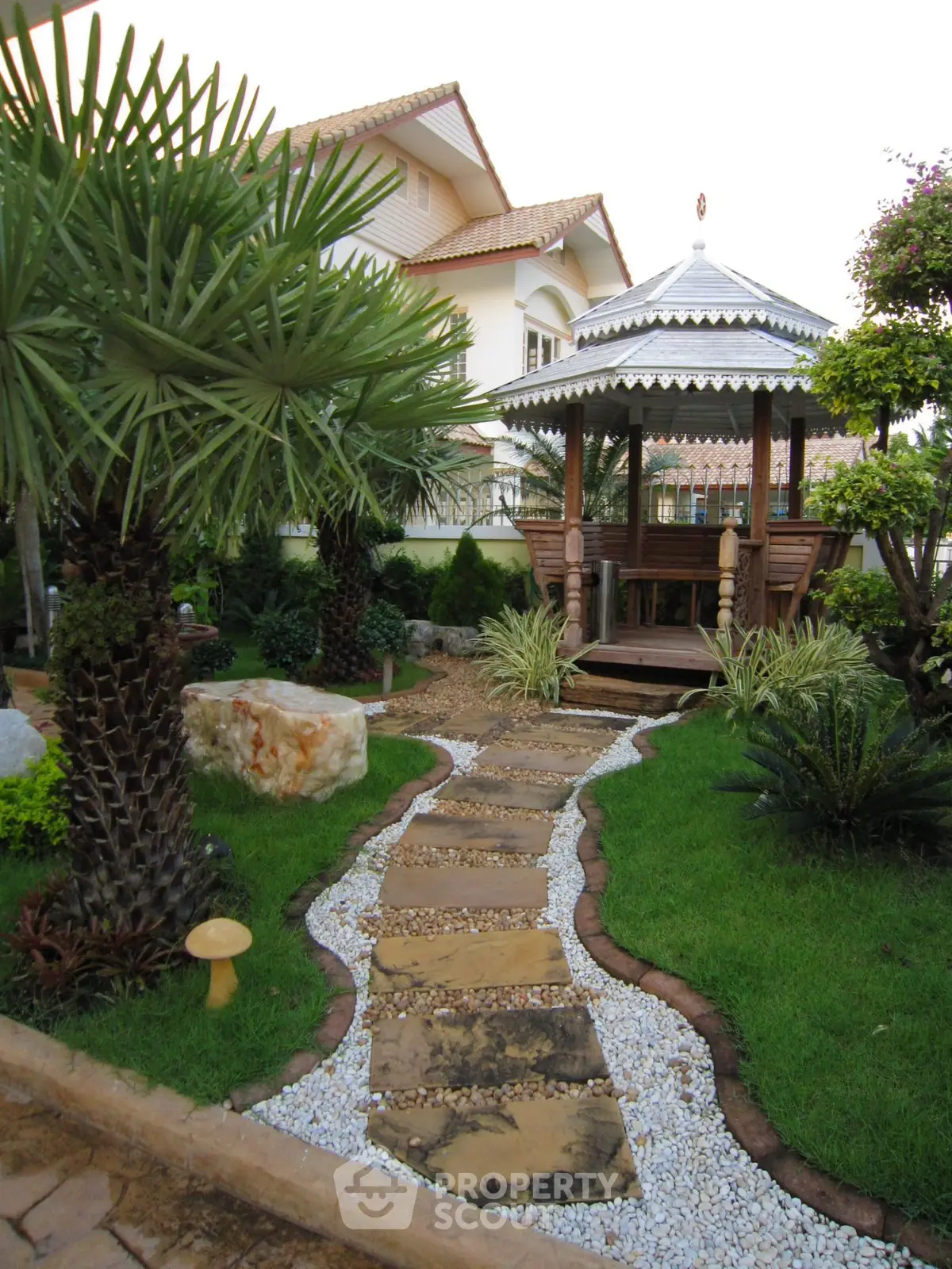 Charming garden with gazebo and lush landscaping in a serene residential setting.