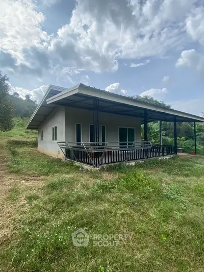 Charming rural house with spacious porch and lush greenery, perfect for nature lovers seeking tranquility.