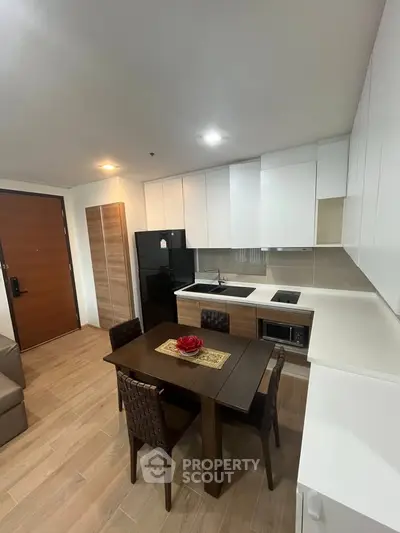 Modern kitchen with sleek cabinetry and dining area in stylish apartment