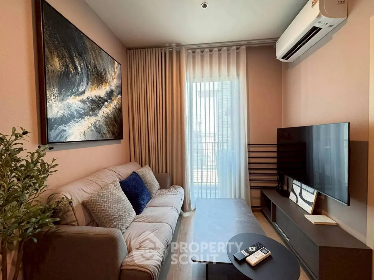 Cozy living room with modern decor, large artwork, and natural light from balcony window.