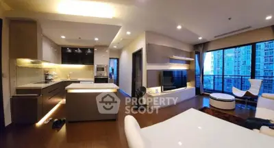 Modern open-layout living room with kitchen, featuring sleek design and large windows with city view.