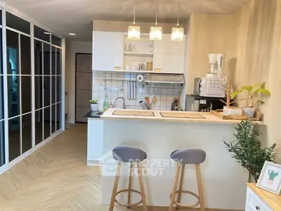 Chic modern kitchen with breakfast bar and stylish lighting in open layout apartment.