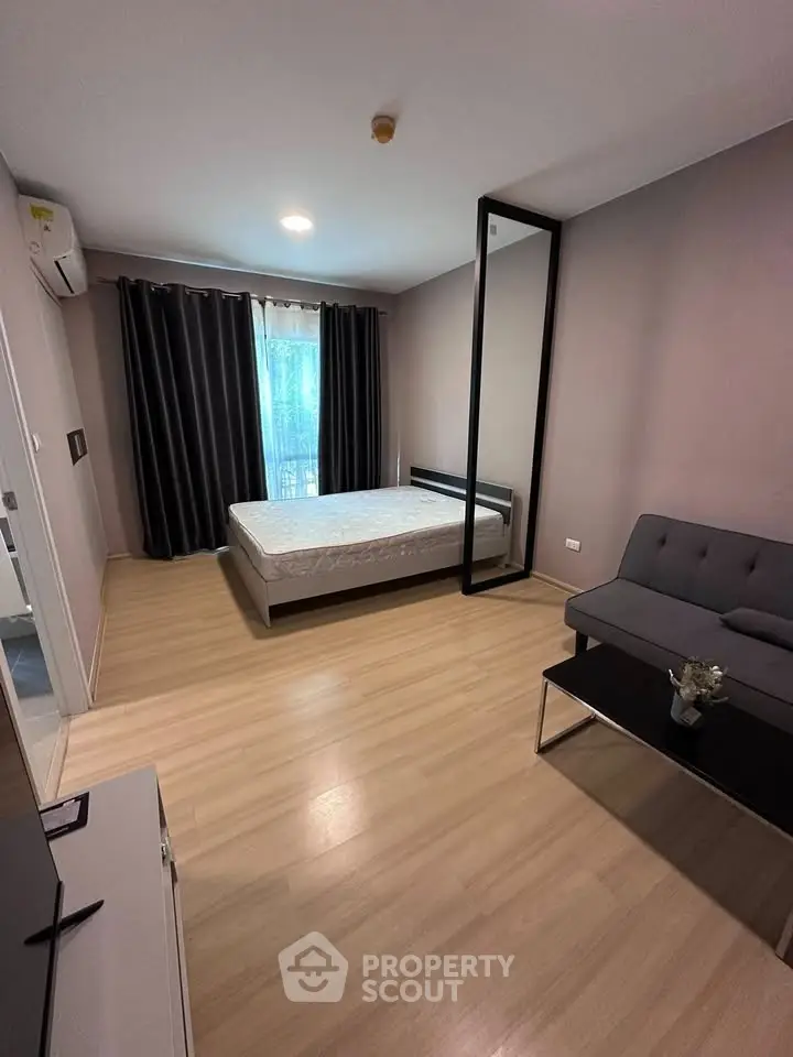 Modern bedroom with sleek design, featuring a comfortable bed, stylish sofa, and large window with curtains.