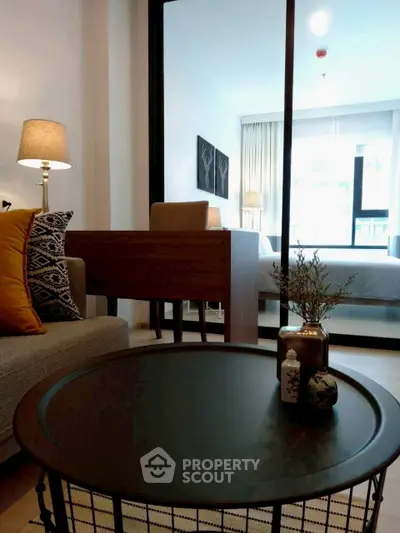 Modern living room with stylish decor and a glimpse into a cozy bedroom.