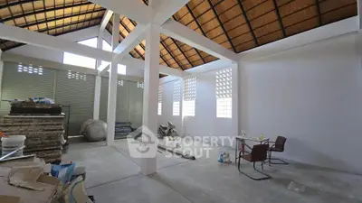 Spacious unfinished interior with high ceilings and natural light