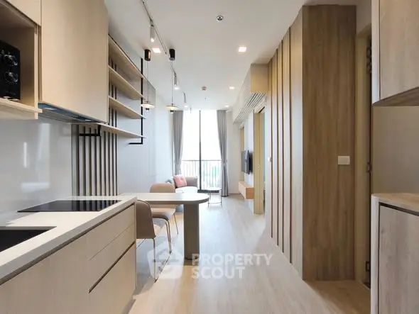 Modern open-layout kitchen and living room with sleek design and natural light.