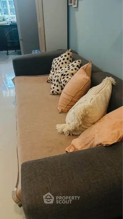 Cozy living room with stylish sofa and decorative pillows, perfect for relaxation and comfort.