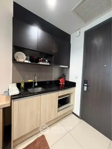 Modern compact kitchen with sleek cabinetry and appliances in a stylish apartment.
