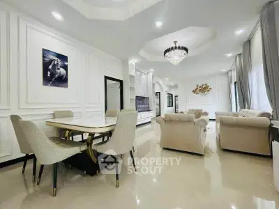 Luxurious open-plan living and dining area with elegant decor and chandelier lighting.