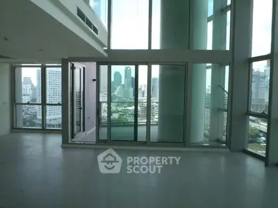 Spacious modern living room with floor-to-ceiling windows and city view
