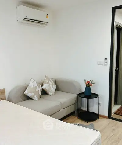 Cozy bedroom with modern sofa and air conditioning, perfect for relaxation.