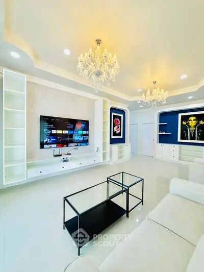 Luxurious living room with chandeliers and modern entertainment setup