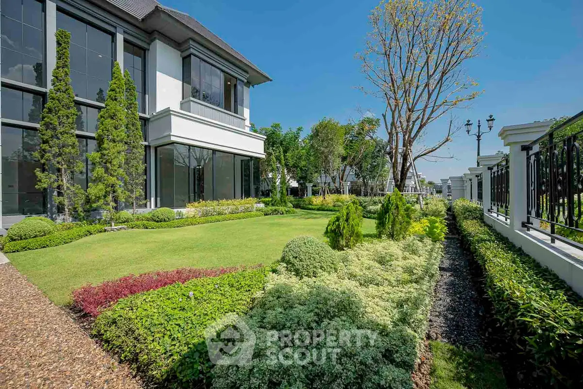 Luxurious garden view of modern building with lush landscaping and elegant architecture.