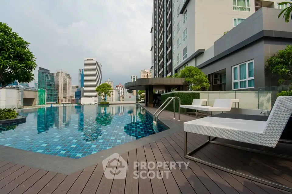 Luxurious rooftop pool with city skyline view in modern high-rise building.