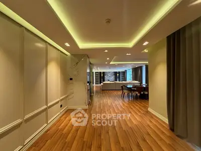 Luxurious open layout living space with elegant wood flooring and modern lighting.