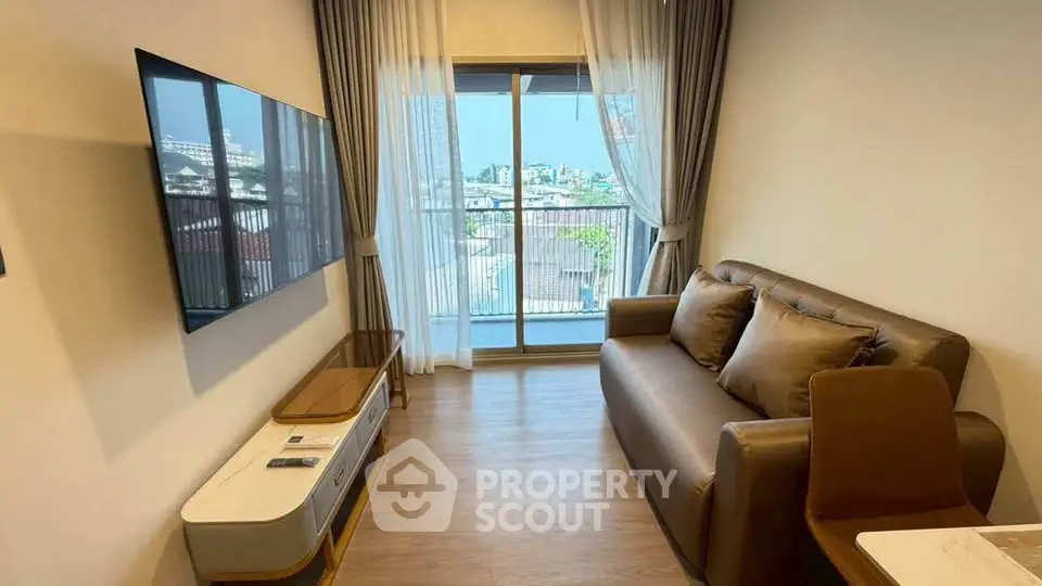 Modern living room with large TV and balcony view in urban apartment
