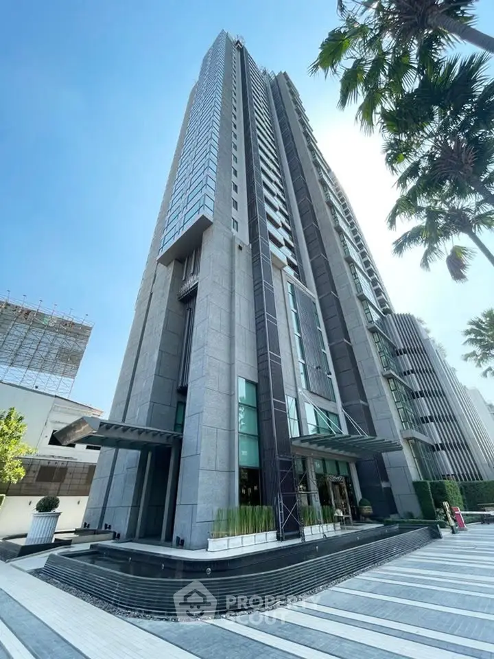 Stunning modern high-rise building with sleek architecture and lush surroundings, perfect for urban living.