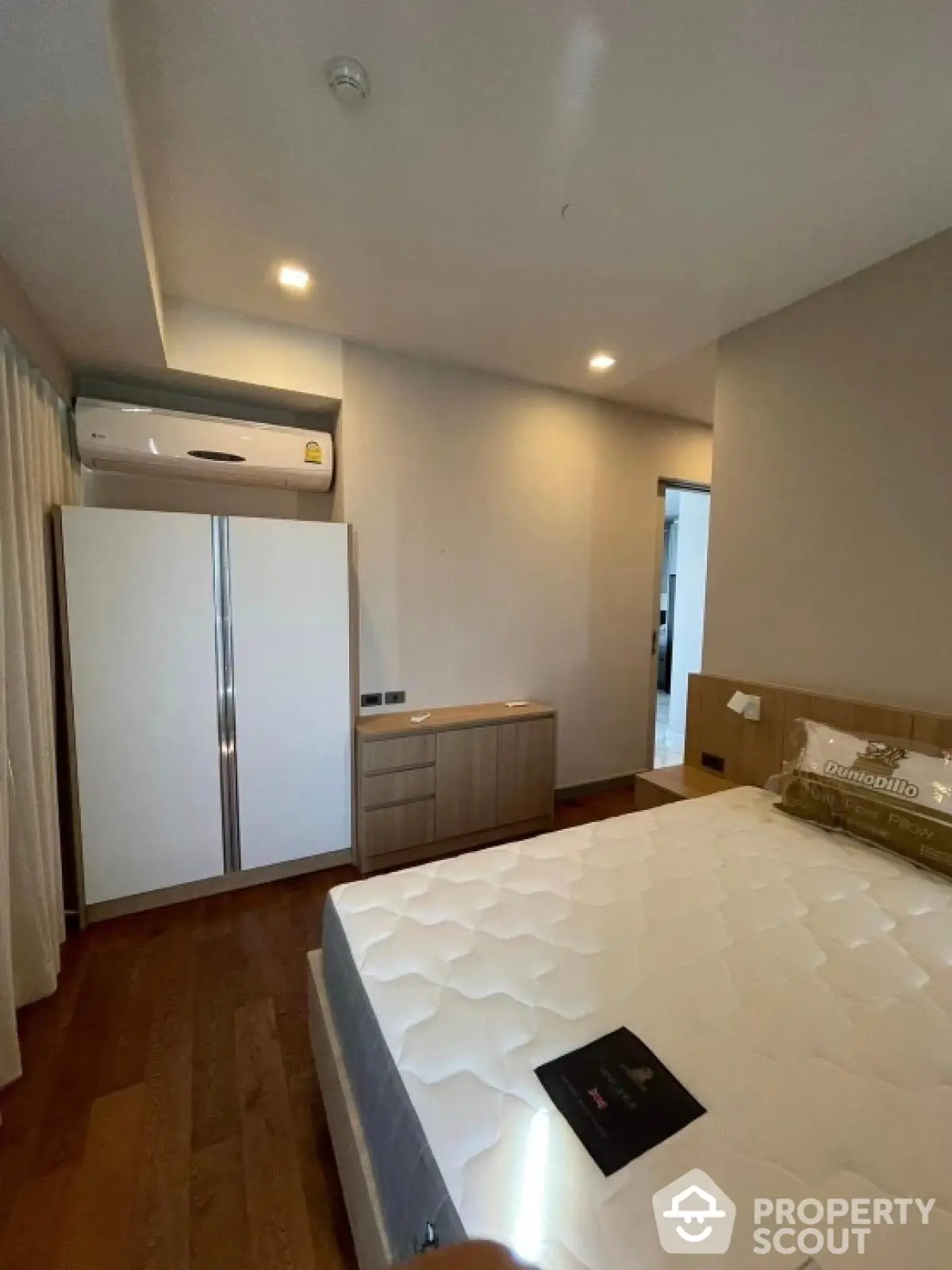 Modern bedroom with wooden flooring and built-in wardrobe in a stylish apartment.