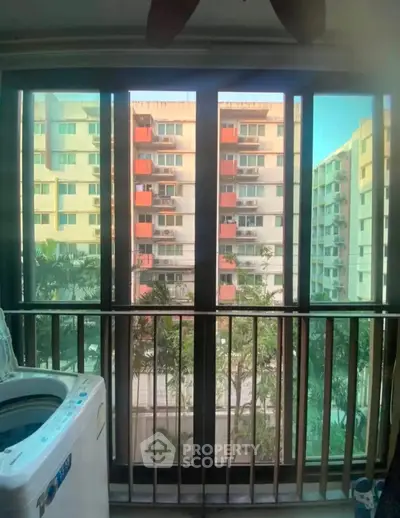 Spacious balcony with washing machine and city view in modern apartment