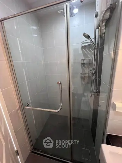 Modern bathroom with sleek glass shower enclosure and chrome fixtures.
