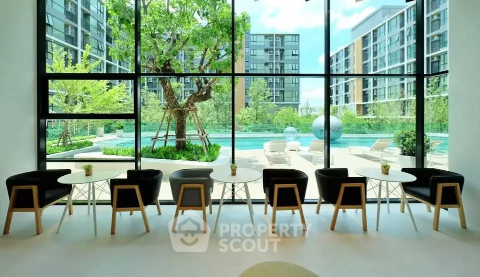 Modern apartment complex with pool view from stylish lounge area.