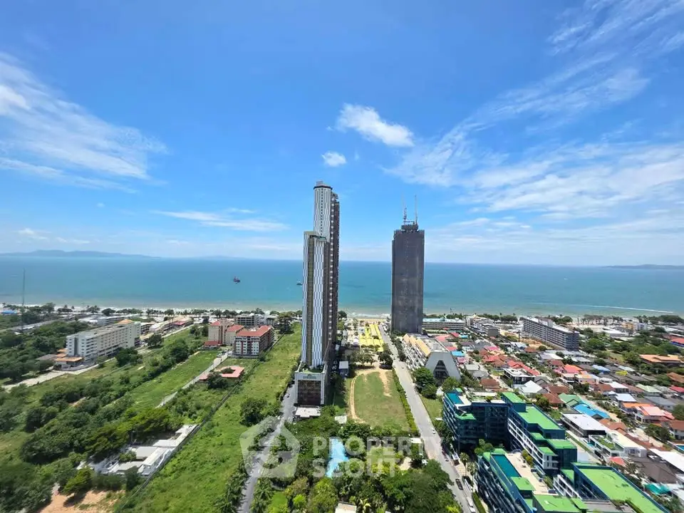Stunning aerial view of coastal cityscape with modern high-rise buildings and ocean backdrop.