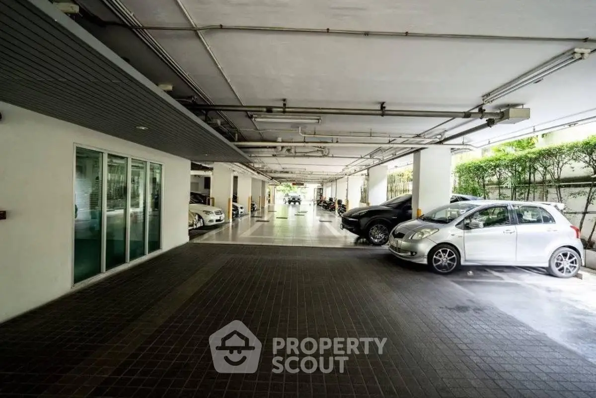 Spacious covered parking area with multiple cars in a modern building.