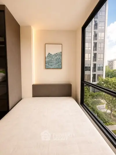 Modern bedroom with large windows offering a stunning city view, featuring minimalist decor and natural light.