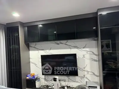 Modern living room with sleek black cabinetry and marble accent wall