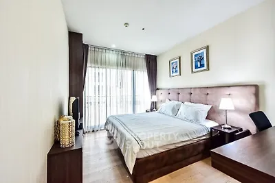 Spacious and elegantly furnished bedroom with large window and stylish decor