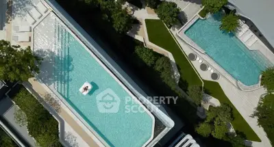 Luxurious aerial view of modern rooftop pools surrounded by lush greenery in a high-end residential complex.