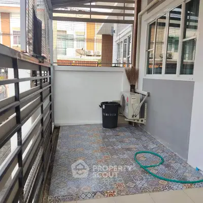 Charming outdoor patio with decorative tiles and modern fencing, perfect for relaxation.