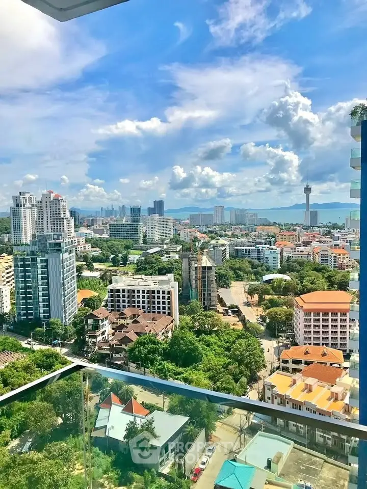 Stunning cityscape view from a high-rise balcony with lush greenery and skyline.
