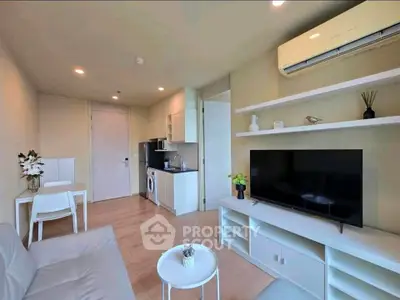 Modern living room with sleek furniture and built-in appliances in a cozy apartment.