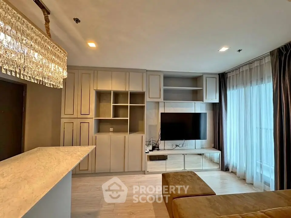 Modern living room with elegant chandelier and built-in TV unit